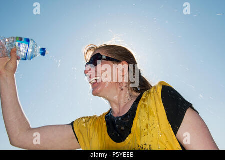 Model Released Frau genießen Sie eine Flasche Quellwasser an einem heißen Tag. Stockfoto