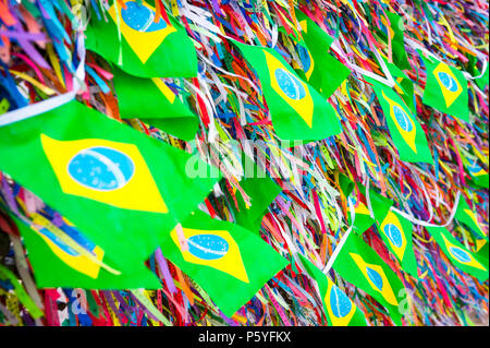 Brasilianische Fahnen fliegen auf eine Wand der Wunsch Bänder an der berühmten Kirche Nosso Senhor do Bonfim Salvador de Bahia. Übersetzung: Ordnung und Fortschritt, unser L Stockfoto