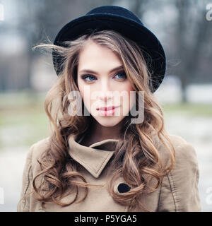 Perfekte junge Frau in schwarzen Hut draußen im Park. Perfekte weibliche Gesicht Nahaufnahme Stockfoto