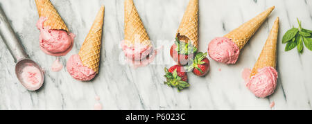 Flachbild-lay von hausgemachtem Joghurt Erdbeer Eis in Waffeln. Stockfoto