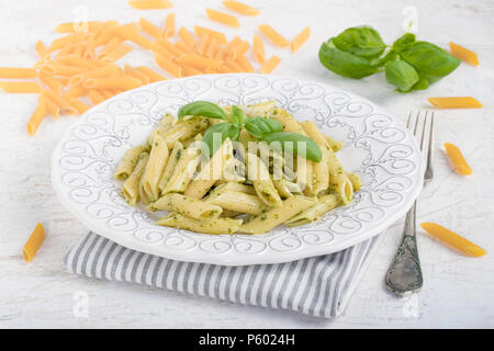 Penne Rigate Nudeln mit Basilikum Pesto auf weißem Hintergrund. Stockfoto