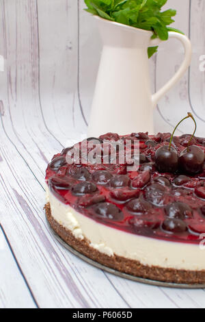 Kalte Käsekuchen mit Kirschen Gelee auf Tabelle Stockfoto