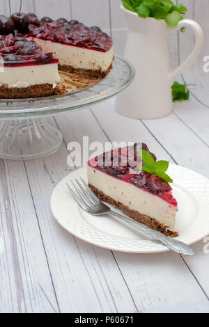 Kalte Käsekuchen mit Kirschen Gelee auf Tabelle Stockfoto