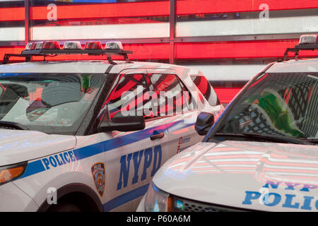 NYPD Fahrzeuge vor einem Neon Sterne und Streifen in Times Square in New York City Stockfoto