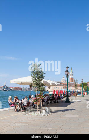 Die Menschen genießen einen Sundowner am Fondamenta Zitelle, der Insel Giudecca, Venedig, Venetien, Italien mit Blick auf den Giudecca Kanal Stockfoto