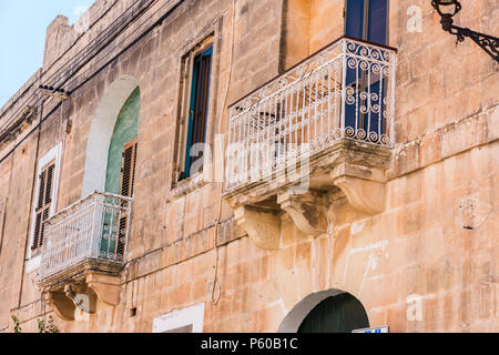 Traditionelle schmiedeeiserne Balkone auf einem Gebäude in der kleinen maltesischen Ortschaft Gudja, Malta. Stockfoto