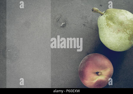 Frische reife Früchte der Saison auf einen Stein Oberfläche - Birne und Pfirsich Stockfoto