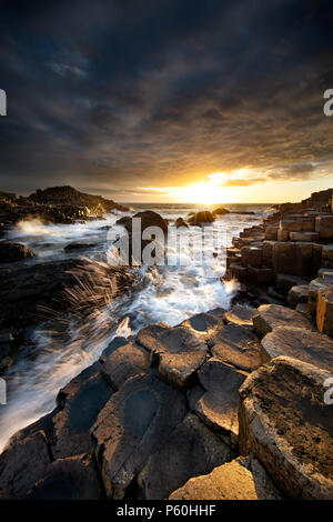 Wellen in Giant's Causeway bei Sonnenuntergang Stockfoto