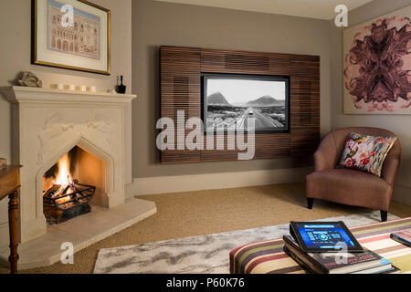 Lit Feuer durch Flachbildfernseher im Wohnzimmer. Stockfoto