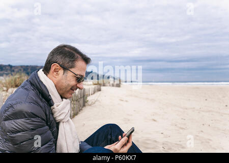 Mann am Strand mit seiner Zelle Stockfoto
