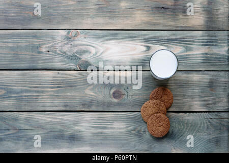 Haferflocken Kekse und ein Glas Milch auf einem alten grünen Holz- Hintergrund mit Platz für Ihren Text Stockfoto