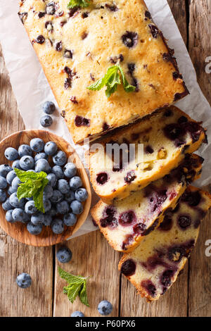Frische Heidelbeeren Laib Brot muffin Kuchen mit Minze closeup auf einem Tisch. Senkrechte Draufsicht von oben Stockfoto