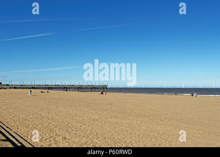 Skegness Strand und Pier mit einem windpark am Horizont Stockfoto