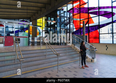 Junge Frau consulting Ihr Handy in Champ-de-Mars Metro Station, Montreal, Provinz Quebec, Kanada. Stockfoto