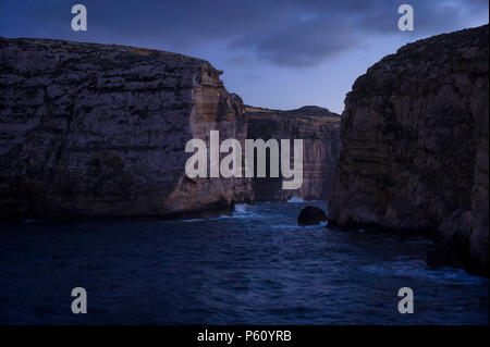 Klippen in Insel Gozo (Dwejra Bay) in der Abenddämmerung. Auf der rechten Seite Fungus Rock. Winter, Malta. Stockfoto