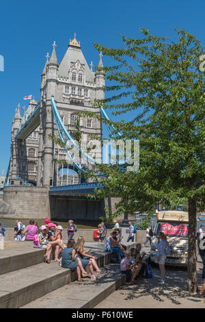 Lond, UK, 27. Juni 2018. Die hitzewelle weiter in Central London mit blauem Himmel und potenziell brechen Temperaturen erfassen. Massen von Touristen und Büroangestellten an mehr London statt und die Tower Bridge genießen das heiße Wetter und strahlendem Sonnenschein saßen auf dem Gras und Sonnenbaden. Quelle: Steve Hawkins Fotografie/Alamy leben Nachrichten Stockfoto