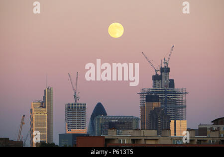 London, Großbritannien. 27 Jun, 2018. Nach dem Anderen scorcher in London und Großbritannien, der Mond über die Gurke und andere Bauen in der City von London, wie der Tag endet. Credit: Monica Wells/Alamy leben Nachrichten Stockfoto