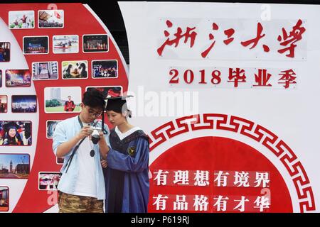 Hangzhou, Zhejiang, China, 28. Juni 2018. Ein Student die Teilnahme an der Abschlussfeier beobachtete das Schießen Wirkung vor der Graduierung an der Wand der Zhejiang Universität, 28. Juni 2018. Credit: Costfoto/Alamy leben Nachrichten Stockfoto