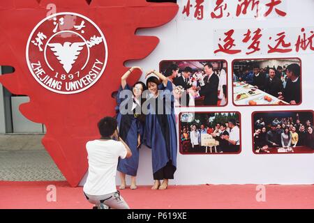 Hangzhou, Zhejiang, China, 28. Juni 2018. Ein Student die Teilnahme an der Abschlussfeier für ein Foto vor der Graduierung an der Wand der Zhejiang Universität, 28. Juni 2018. Credit: Costfoto/Alamy leben Nachrichten Stockfoto