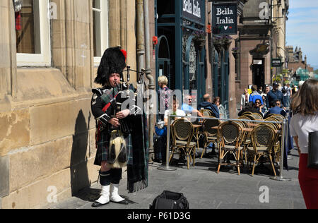 Schottische Dudelsackpfeifer in tartan Kilt Dudelsack spielen auf der Royal Mile in Edinburgh für Touristen in Schottland Stockfoto