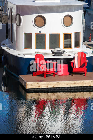 Rote Stühle durch die Yacht in Vancouver Downtown Marina zu entspannen (British Columbia). Stockfoto