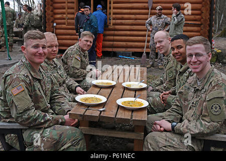 Soldaten zum Hauptsitz und Sitz Truppe, 3 Staffel, 2. Reiterregiment Lächeln für ein Foto zugewiesen, während sie darauf warten, zum Mittagessen nach einem Tag harter Arbeit während einer Community Outreach Projekt an einer christlichen Youth Summer Camp, 9. April in Daugavpils, Lettland. Diese Soldaten in der Region Unterstützung Betrieb Atlantic Lösen verbrachte einen Samstag Geben zurück zu der Gemeinschaft. (U.S. Armee Foto von Sgt. Paige Behringer, 10 Drücken Sie Camp Headquarters Stockfoto