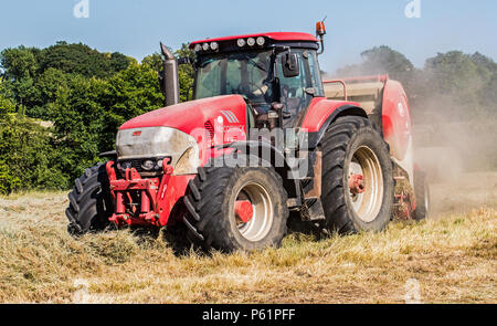 Landwirtschaft in England mit einem großen, roten Traktor Stockfoto