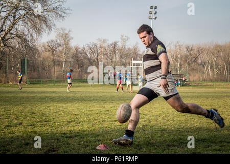 Belgrad, Serbien - 1. MÄRZ 2015: Junger Mann schießen auf einen rugby ball tun Drop Ziel während einer Partizan Rugby Team Training Bild der weißen Jungen Stockfoto