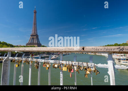 Paris, Frankreich, 23. Juni 2018: Liebe Vorhängeschlösser auf Debilly Fußgängerbrücke mit dem Eiffelturm im Hintergrund. Stockfoto