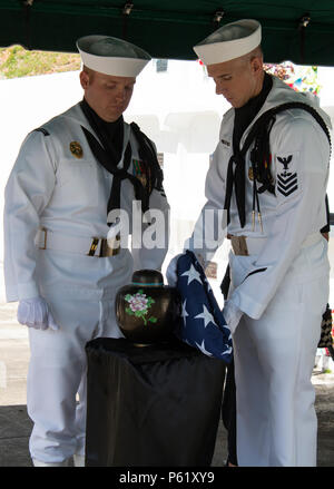 SANTA Rita, Guam (1. April 2016) - Master at Arms 1. Klasse Robert Schmidt (links) und Aviation Ordnanceman 1. Klasse James Stein die Urne und Flag zur Vorlage bei der Familie vorbereiten. Drei Segler und Flieger aus der gemeinsamen Region Marianen (Jrm) Beerdigung Ehrungen durchgeführt bei einer Beerdigung für eine Guam Veteran, am 1. April an der Guam Veteranen Friedhof. Segler und Flieger widmen ihre Zeit zum Ehren zu Veteranen und ihre Familien bei Begräbnissen auf der Insel zur Verfügung zu stellen, die Durchführung von durchschnittlich vier pro Monat. (Erschienen/Jeff Landis, Major, USMC (Ret.), Direktor für Öffentliche Angelegenheiten/Kommunikation, Stockfoto