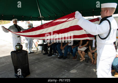 SANTA Rita, Guam (1. April 2016) - Master at Arms 1. Klasse Robert Schmidt (rechts) und Aviation Ordnanceman 1. Klasse James Stein bereiten Sie die Flagge zur Vorlage bei der Familie zu falten. Drei Segler und Flieger aus der gemeinsamen Region Marianen (Jrm) Beerdigung Ehrungen durchgeführt bei einer Beerdigung für eine Guam Veteran, am 1. April an der Guam Veteranen Friedhof. Segler und Flieger widmen ihre Zeit zum Ehren zu Veteranen und ihre Familien bei Begräbnissen auf der Insel zur Verfügung zu stellen, die Durchführung von durchschnittlich vier pro Monat. (Erschienen/Jeff Landis, Major, USMC (Ret.), Direktor für Öffentliche Angelegenheiten/Kommunikation Stockfoto