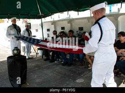 SANTA Rita, Guam (1. April 2016) - Master at Arms 1. Klasse Robert Schmidt (rechts) und Aviation Ordnanceman 1. Klasse James Stein bereiten Sie die Flagge zur Vorlage bei der Familie zu falten. Drei Segler und Flieger aus der gemeinsamen Region Marianen (Jrm) Beerdigung Ehrungen durchgeführt bei einer Beerdigung für eine Guam Veteran, am 1. April an der Guam Veteranen Friedhof. Segler und Flieger widmen ihre Zeit zum Ehren zu Veteranen und ihre Familien bei Begräbnissen auf der Insel zur Verfügung zu stellen, die Durchführung von durchschnittlich vier pro Monat. (Erschienen/Jeff Landis, Major, USMC (Ret.), Direktor für Öffentliche Angelegenheiten/Kommunikation Stockfoto