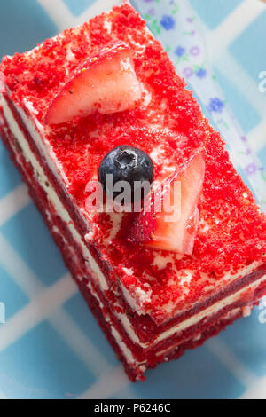 Red Velvet Cake mit Sahne, Erdbeeren und Heidelbeeren Stockfoto