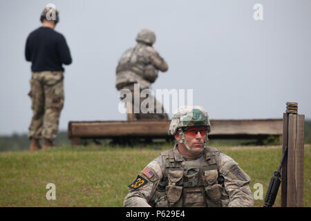 U.S. Army Staff Sgt. Joshua Rolfes wartet geduldig auf seine Schlacht Buddy 1 Sgt David Floutier, in die Luft und Ranger Training Feuerwehr zugewiesen, mit seinem M4 Sturmgewehr während der Stress schießen auf Malone 15, Fort Benning, Ga, 15. April 2016 zu qualifizieren. Die 33. jährliche besten Ranger Wettbewerb 2016 ist eine dreitägige Veranstaltung, bestehend aus Herausforderungen Wettbewerber des körperlichen, geistigen und technischen Fähigkeiten zu Ehren von Generalleutnant David E. Grange, Jr. auf Ft. Benning, Ga, 15. April 2016. (U.S. Armee Foto von Sgt. Austin BernerReleased) Stockfoto