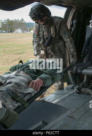 Sgt. Carlton Quenneville, Crew Chief, Charlie Company, 3.BATAILLON, 126 Aviation Regiment (Air Ambulance), hilft bei einem Unfall während der Verteidigung und Unterstützung der zivilen Behörden bei der Army Aviation Support Facility, South Burlington, VT April 2, 2016. Die Ausbildung ist die Vorbereitung für die Wachsam Guard, National Emergency Response Übung. (U.S. Army National Guard Foto von SPC. Avery Cunningham) Stockfoto