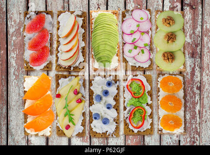 Sandwiches mit Frischkäse und frische Beeren, Früchte und Gemüse. Frische, gesunde Vorspeise Snack mit Knäckebrot. Stockfoto