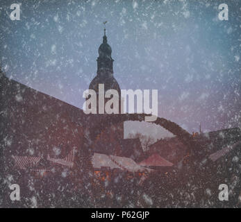 Weihnachtsmarkt mit einem Schneefall auf dem Domplatz mit Dom in Riga Stockfoto