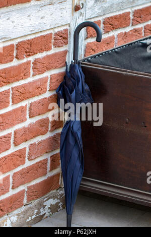 Schwarz Regenschirm auf Mauer Hintergrund schliessen. Stockfoto
