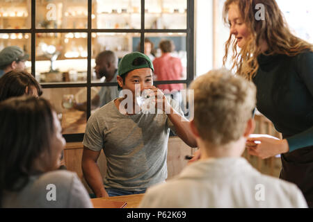 Vielfältige Gruppe von Freunden essen Bestellen aus einem Bistro Kellnerin Stockfoto