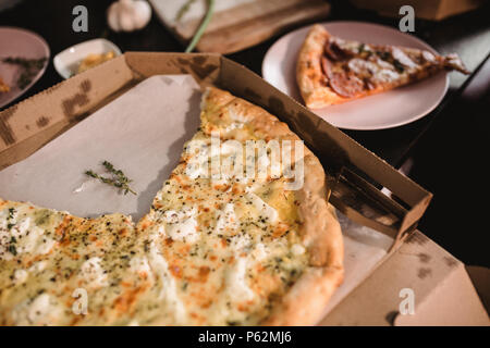 Pizza auf Holztisch mit hellen Platten für die Partei. Dunklen rustikalen Toning essen Foto. Top Bild anzeigen. Stockfoto