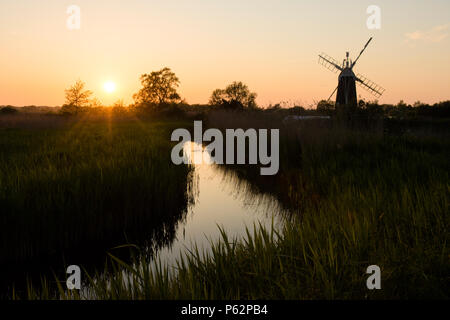 Rasen Fen Entwässerung Mühle, wie Hügel, Norfolk Broads, Sonnenuntergang, Entwässerungsgraben und Schilf, Mai. Stockfoto