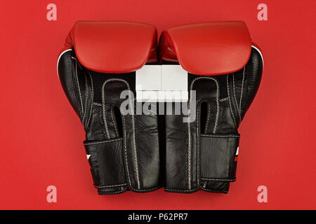 Leder Boxhandschuhe halten Sie die Holz- Kalender auf roten Hintergrund. Vorlage mock up für eine Grußkarte an des Vaters, Valentines Tag und Geburtstag feiern. Stockfoto