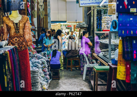 Yangon, Myanmar - Feb 19 2014: Frauen in einem Tuch Geschäfte Stall der Bogyoke Aung San Market Stockfoto