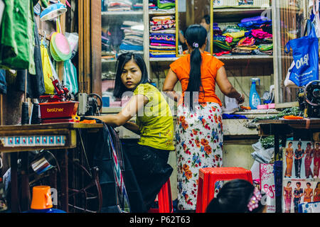 Yangon, Myanmar - Feb 19 2014: Frauen in einem Tuch Geschäfte Stall der Bogyoke Aung San Market Stockfoto