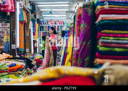 Yangon, Myanmar - Feb 19 2014: Frauen in einem Tuch Geschäfte Stall der Bogyoke Aung San Market Stockfoto