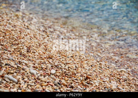 Kieselsteine am Meer. Seidig Wellen des blauen Meer. Der Strand Steine am Ufer des Meeres. Die Küste Stockfoto