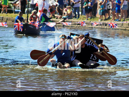 Die letzten paar Paddel in einem Floß Rennen auf dem Leeds und Liverpool Canal finden Sie in der Team von Supermarkt Zweiter im Rennen der lokalen Stand. Stockfoto