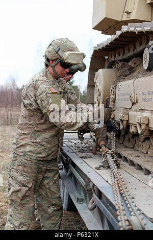 Spc. Jonathan Renfro (vorne) und Sgt. Zachary Krämer, beide Brücke Crewmitglieder für die Zentrale und Hauptverwaltung Truppe, 3 Staffel, 2 Cavalry Regiment zugeordnet, Ketten aus einer D6-Bulldozer entfernen Vor dem Graben kämpfen Positionen für Stryker gepanzerten Kampffahrzeugen, 5. April, an Adazi Militärbasis, Lettland. Soldaten auch verwendet, um eine hohe Mobilität Ingenieur Bagger kämpfen Positionen für die Lettische Verbündeten zu graben, bevor eine multinationale kombinierte Verteidigung live-fire Übung zur Unterstützung der Operation Atlantic lösen, eine multinationale Demonstration der anhaltenden US-Engagement für die kollektive Sicherheit Stockfoto