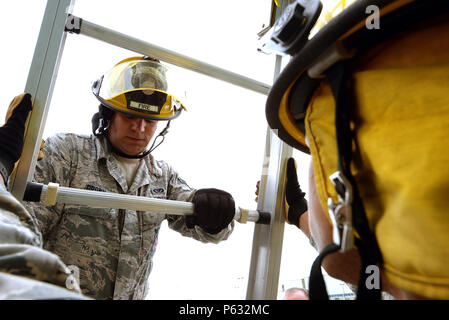 Airman 1st Class Kenneth Brown von der 177th Fighter Wing Feuerwehr, New Jersey Air National Guard, Klettert eine Leiter von Airman 1 st statt. Klasse Trey Gates während einer Leiter Betrieb training Übung bei der die 165 Airlift Wing World Fire Training Facility auf April 12,2016. Flieger vom New Jersey Air National Guard Feuerwehr sind die Durchführung von Übungen Betriebsbereitschaft aufrecht zu erhalten. (U.S. Air National Guard Foto von Tech. Sgt. Andrew J. Merlock/Freigegeben) Stockfoto