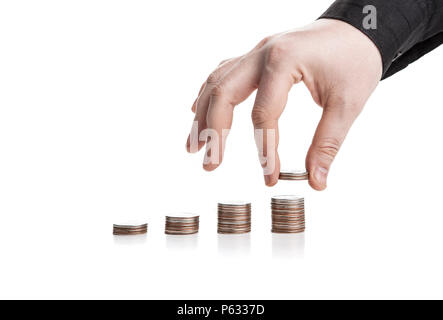 Stapel von Münzen und die menschliche Hand auf weißem Hintergrund Stockfoto